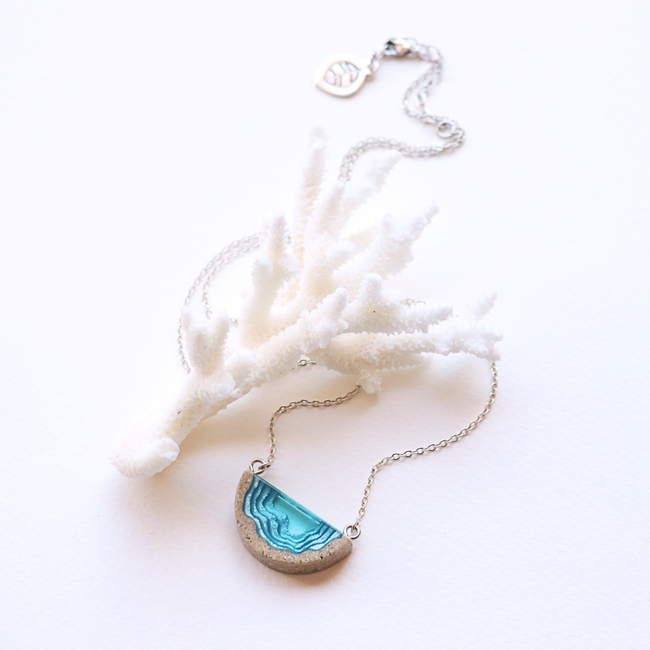 Dainty beach sand and blue resin necklace with white background